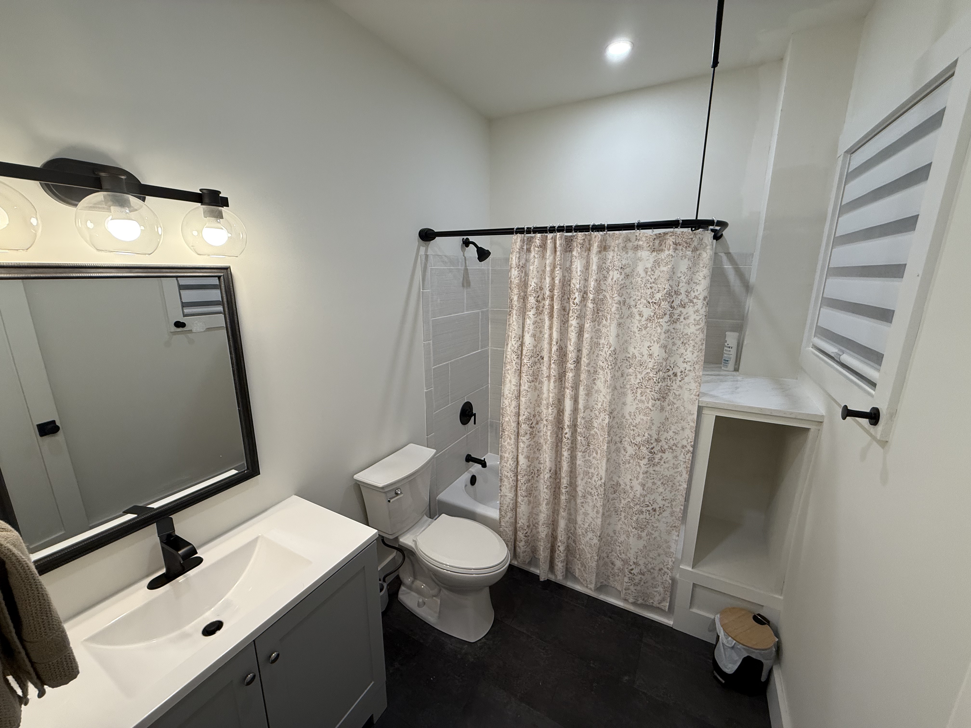 Full bathroom with tub and floral shower curtain