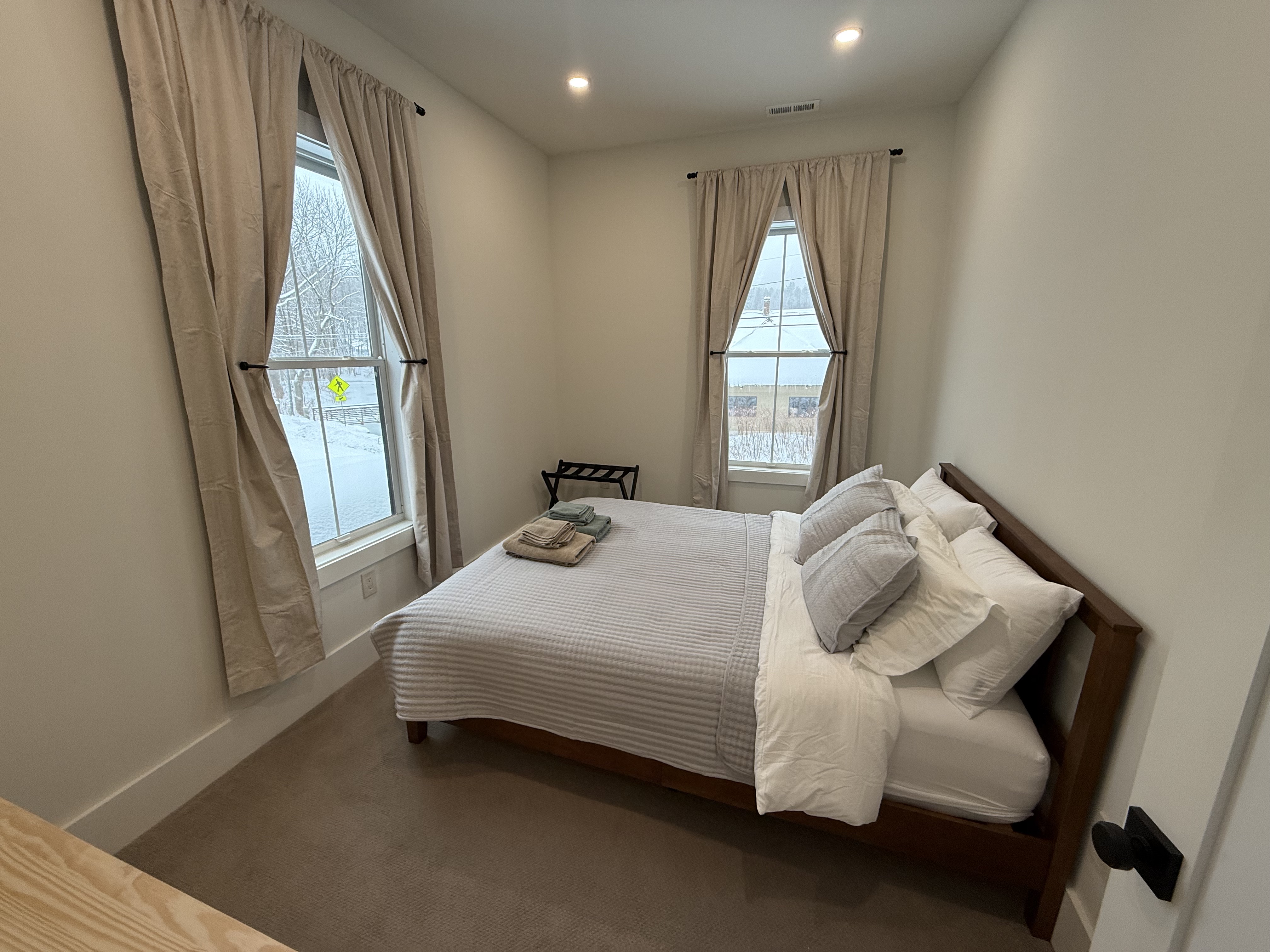 Bedroom one with queen bed and two windows