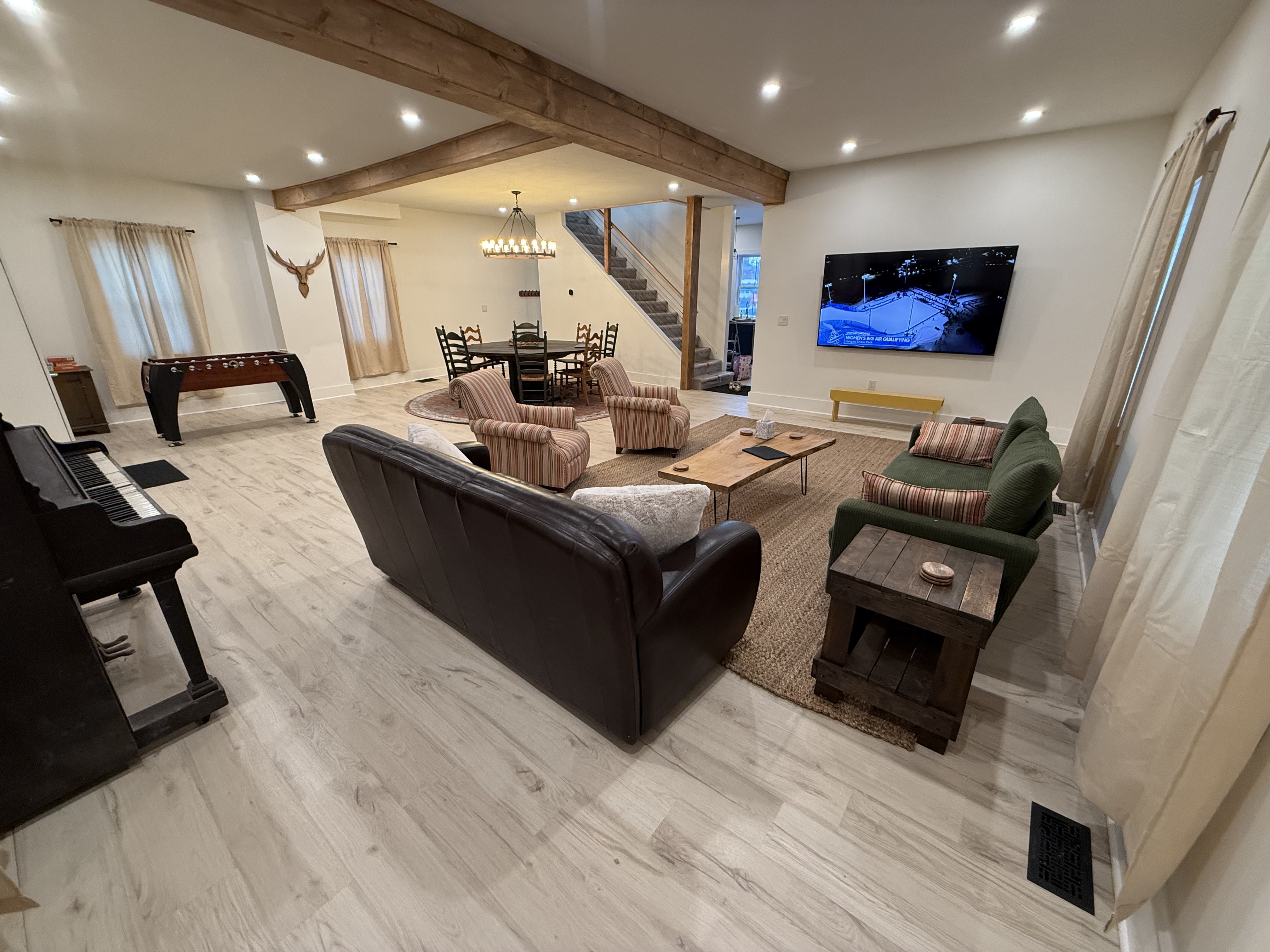 Great room with foosball, dining table, and the Okemo Mountain sign above the front door