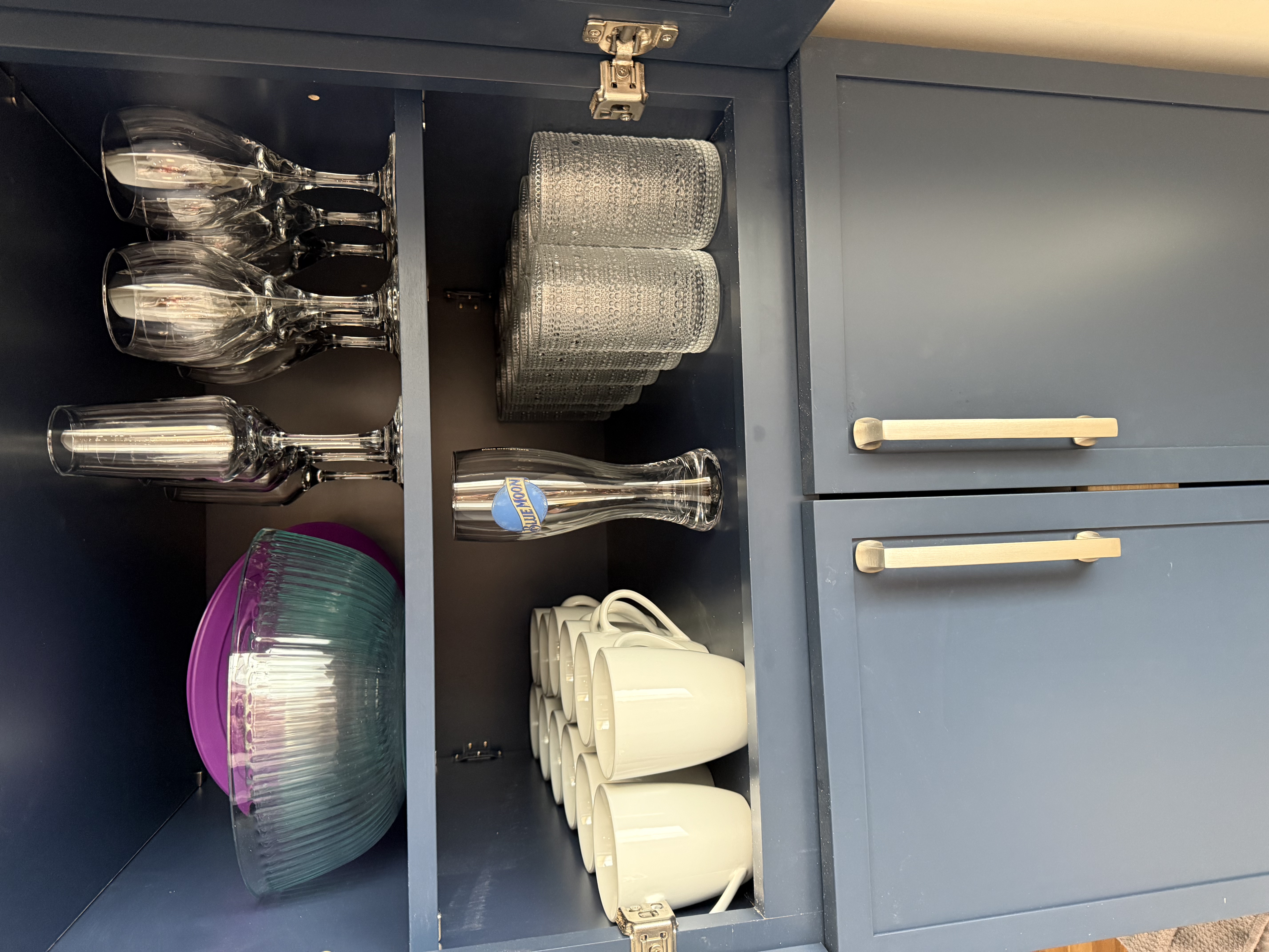 Fully stocked glassware and dishware cabinet
