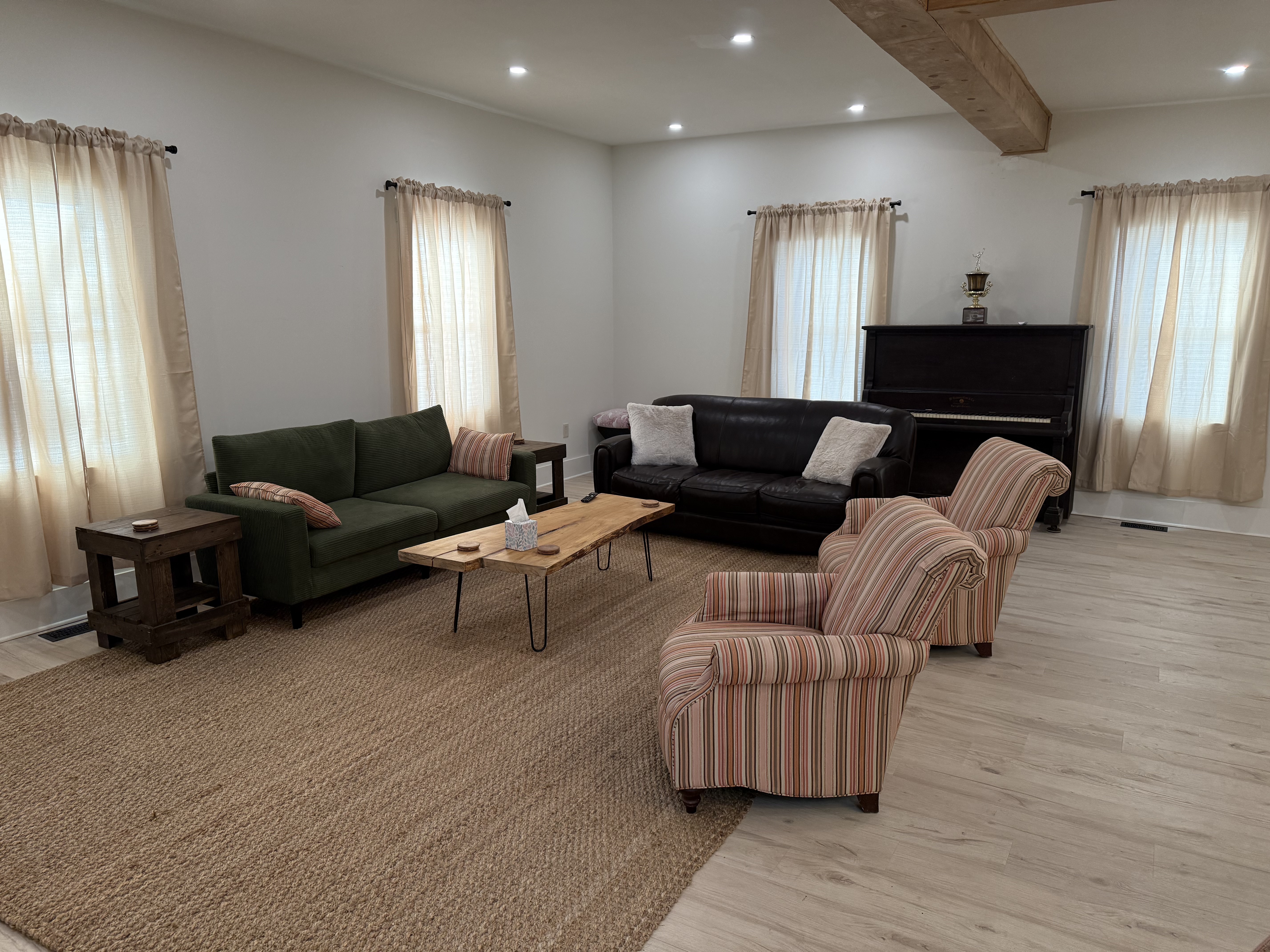 Living room with sofas, armchairs, and a piano